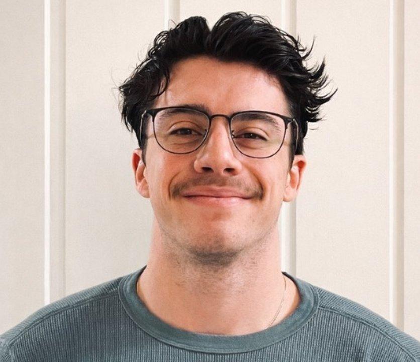 TogetherWON trainer Alex Oliver smiling in glasses and a green sweater