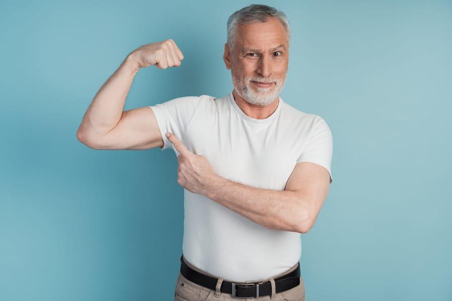 Smiling older man flexing his bicep